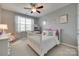 A well-lit bedroom featuring a ceiling fan, neutral walls, and a large window at 525 Chase Prairie Ln, Waxhaw, NC 28173
