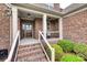Close-up of front porch with brick steps, white railings, columns, and decorative front door at 525 Chase Prairie Ln, Waxhaw, NC 28173