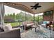 Relaxing screened porch with stylish furniture, ceiling fan, brick accent wall, and backyard view at 525 Chase Prairie Ln, Waxhaw, NC 28173