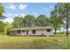 Rear view of the home, showcasing a screened porch and green lawn area, surrounded by large trees at 5317 Friendly Baptist Ch Rd, Indian Trail, NC 28079