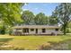 View of the back of the one-story home featuring a screened-in porch and a well-manicured lawn at 5317 Friendly Baptist Ch Rd, Indian Trail, NC 28079