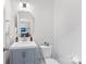 Small half-bathroom with gray vanity, white toilet, and a beveled mirror above the sink at 548 Dutch White Dr, Clover, SC 29710