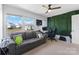 Bright bedroom featuring a gray sofa, ceiling fan, large windows, and an accent wall for a modern touch at 548 Dutch White Dr, Clover, SC 29710