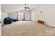 Spacious bonus room with a ceiling fan, natural light, and comfortable sofa at 5722 Kirkwynd Commons Dr, Charlotte, NC 28278