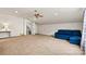 Spacious bonus room featuring neutral carpet, ceiling fan, and a comfortable blue sectional sofa at 5722 Kirkwynd Commons Dr, Charlotte, NC 28278