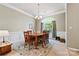 Traditional dining room featuring decorative rug, chandelier lighting, and large window at 5722 Kirkwynd Commons Dr, Charlotte, NC 28278