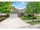 Brick home with a two-car garage, a well-manicured lawn, and mature trees at 5722 Kirkwynd Commons Dr, Charlotte, NC 28278