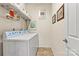 Functional laundry room with white washer, dryer, overhead shelving and tile flooring at 5722 Kirkwynd Commons Dr, Charlotte, NC 28278