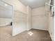 Walk-in closet includes wire shelving, lighting, and tan carpeted floors at 5722 Kirkwynd Commons Dr, Charlotte, NC 28278