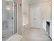 This bathroom has light tile, a large mirror, and makeup chair next to a shower and soaking tub at 5803 Lindley Crescent Dr, Indian Trail, NC 28079