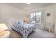 A carpeted bedroom is furnished with a patterned bed, lamps, and decoratively adorned window at 5803 Lindley Crescent Dr, Indian Trail, NC 28079