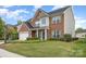 Attractive two-story brick home with a pristine lawn, two-car garage and manicured hedges at 5803 Lindley Crescent Dr, Indian Trail, NC 28079
