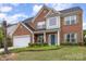 Charming two-story brick home with a well-manicured lawn and inviting front porch at 5803 Lindley Crescent Dr, Indian Trail, NC 28079