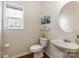 Elegant powder room featuring wood flooring, pedestal sink, and round mirror at 5803 Lindley Crescent Dr, Indian Trail, NC 28079