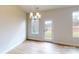 Bright dining area with modern chandelier, hardwood floors, and view of nature from several large windows at 606 Banter Ln # 30, Cramerton, NC 28032