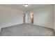 This carpeted bedroom features neutral walls, trim, and carpet. The room also has a door to the ensuite bathroom at 6113 Russo Ct, Lancaster, SC 29720