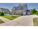 A long driveway leads to this gray two-story home with stone accents and an attached garage at 6113 Russo Ct, Lancaster, SC 29720