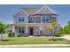 Two-story home featuring stone accents, gray siding, manicured lawn, and professional landscaping at 6113 Russo Ct, Lancaster, SC 29720