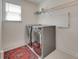 The laundry room features modern washer, dryer, overhead shelving, and a colorful rug to make chores a bit more cheerful at 6113 Russo Ct, Lancaster, SC 29720