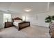 Primary bedroom features dark wood furnishings, carpet flooring, and tray ceilings at 6113 Russo Ct, Lancaster, SC 29720