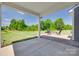 Covered patio featuring brick flooring, ample seating and views of the expansive backyard and blue sky at 6113 Russo Ct, Lancaster, SC 29720