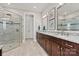 Bathroom featuring double sink vanity, walk in shower, and neutral tile at 7549 Short Putt Ct, Charlotte, NC 28215