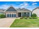 Charming home featuring a stone facade, a welcoming porch, and a well-manicured front yard at 7549 Short Putt Ct, Charlotte, NC 28215
