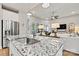Open kitchen island with granite countertops, stainless steel sink, and views of the living room at 7549 Short Putt Ct, Charlotte, NC 28215