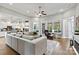 Spacious living room with large sectional sofa, ceiling fan, and seamless flow to the open kitchen at 7549 Short Putt Ct, Charlotte, NC 28215