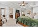 View of bedroom features private en suite bath, television, and cozy green comforter on the bed at 7549 Short Putt Ct, Charlotte, NC 28215