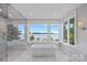 Bright bathroom featuring a soaking tub with water view, a marble shower and a double vanity at 7861 Live Oaks Dr, Denver, NC 28037