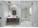 A luxurious bathroom features a unique mirror, a glass-enclosed shower, and marble countertops at 7861 Live Oaks Dr, Denver, NC 28037
