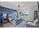 Comfortable bedroom features a blue accent wall, ceiling fan, and a large window with lake views at 7861 Live Oaks Dr, Denver, NC 28037