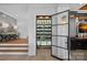 Modern wine cellar with glass door is located near wooden steps with a view into another room at 7861 Live Oaks Dr, Denver, NC 28037