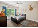 Themed bedroom featuring a dark wood bed frame, ceiling fan, and bright window at 7927 Fairmont Dr, Waxhaw, NC 28173
