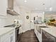Open kitchen with stainless steel appliances, granite countertops, white cabinetry, and dark wood floors at 7927 Fairmont Dr, Waxhaw, NC 28173