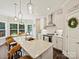 Bright kitchen features white cabinets, granite countertops, a large island, and a view to the outdoor deck at 7927 Fairmont Dr, Waxhaw, NC 28173