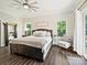 Bright main bedroom featuring a large bed, ceiling fan, and light-filled windows at 7927 Fairmont Dr, Waxhaw, NC 28173