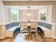 Cozy dining nook featuring banquette seating, white wood paneling, and natural light from two windows at 85 Riley Dr, Taylorsville, NC 28681