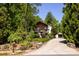 Beautifully landscaped, two-story home featuring a wood deck, detached garage, and winding driveway at 85 Riley Dr, Taylorsville, NC 28681