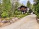 Two-story home with driveway, surrounded by lush greenery and landscaped yard at 85 Riley Dr, Taylorsville, NC 28681