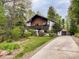 Two-story home with a wood deck, detached garage, long driveway, and a lush, wooded surrounding at 85 Riley Dr, Taylorsville, NC 28681