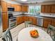 Bright kitchen featuring wooden cabinetry, stainless steel appliances, tile backsplash, and garden view at 85 Riley Dr, Taylorsville, NC 28681