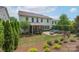 Spacious backyard with an outdoor seating area, custom fire pit, and beautifully landscaped gardens at 866 Tyne Dr, Fort Mill, SC 29715