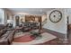 Open-concept living room featuring hardwood floors, a large clock, and seamless access to the kitchen and dining areas at 866 Tyne Dr, Fort Mill, SC 29715