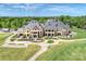 Impressive rear view of the home, featuring patios, manicured lawns, and a charming outdoor seating area at 8716 Ruby Hill Ct, Waxhaw, NC 28173