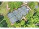 Overhead view of well-maintained tennis courts, surrounded by lush trees and greenery at 8716 Ruby Hill Ct, Waxhaw, NC 28173