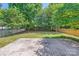 Large backyard with a stone patio, lush lawn, mature trees, and fencing on both sides at 8919 Oransay Way, Charlotte, NC 28278