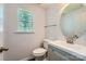 Bright bathroom with a gray vanity, a round mirror, and a window offering natural light at 8919 Oransay Way, Charlotte, NC 28278