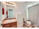 Bathroom featuring a wooden vanity, white cabinets, and a shower with a white curtain at 8919 Oransay Way, Charlotte, NC 28278